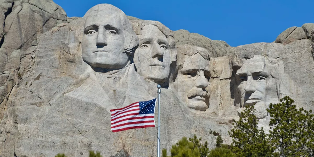 Mount Rushmore National Monument in the Black Hill region of South Dakota, USA with the US flag in the foreground