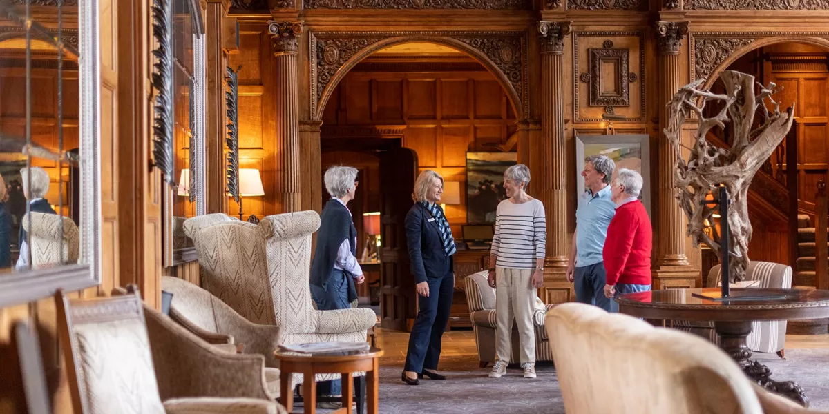 Travel director talking to tourists in Bovey Castle in Devon, England, UK