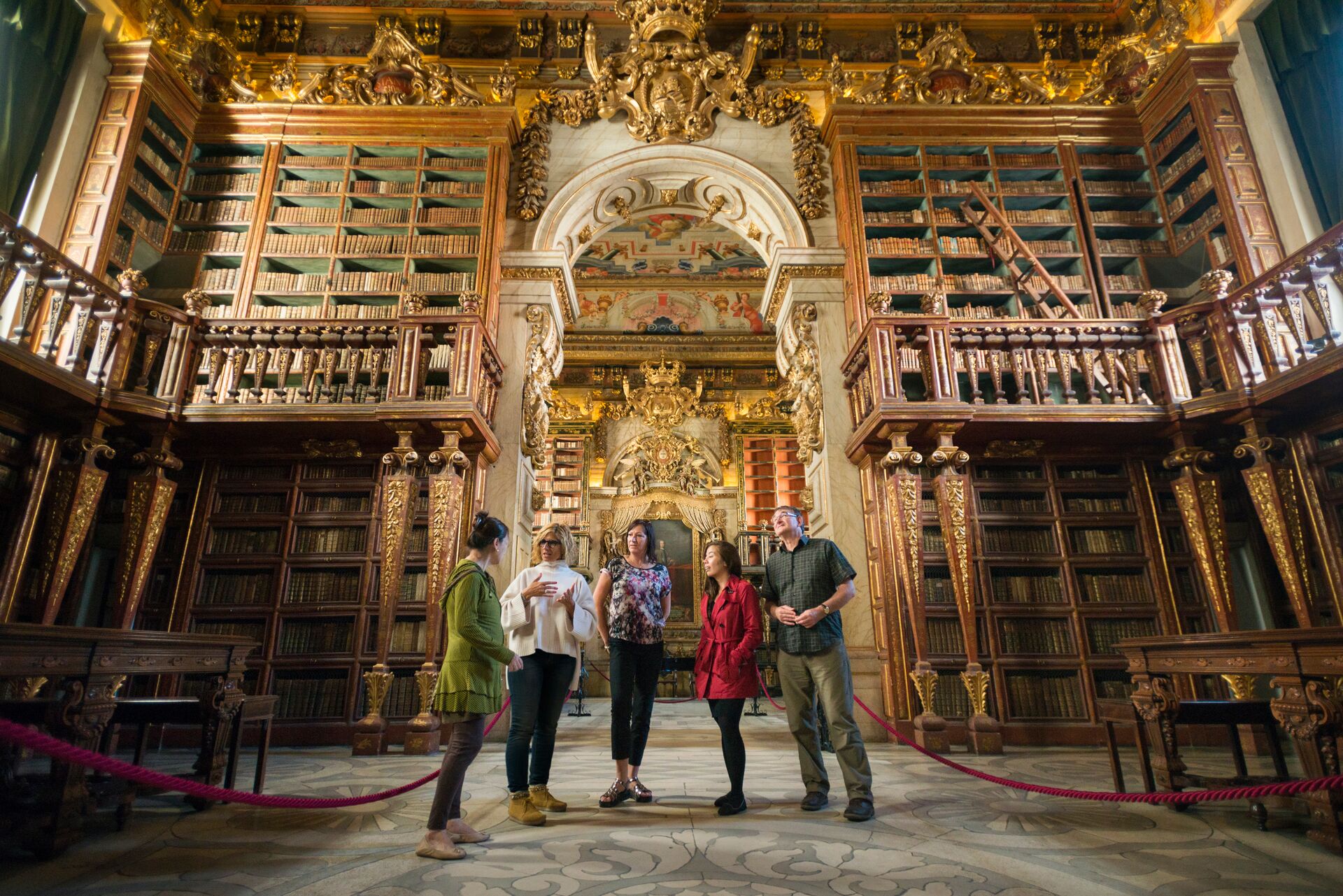 Group of people admiring the baroque library at Coimbra University in Portugal