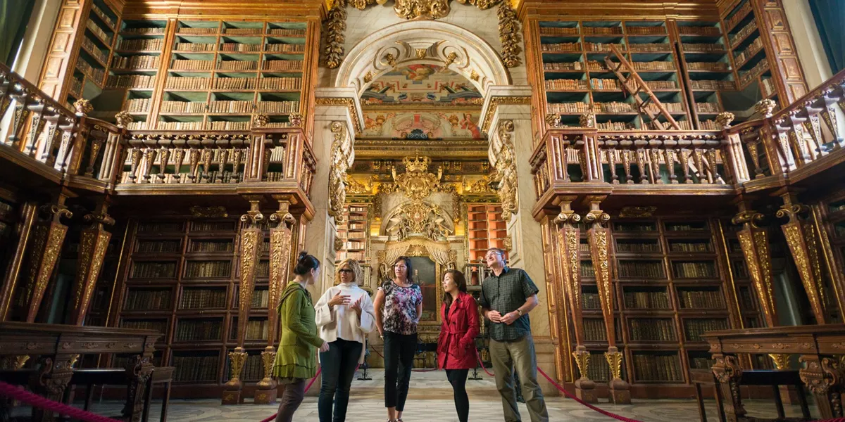 Group of people admiring the baroque library at Coimbra University in Portugal