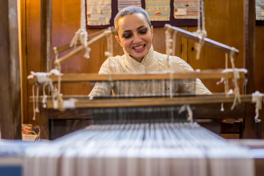 A smiling woman is yarning
