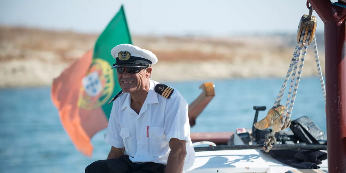 Captain smiling while sitting on his boat in Portugal