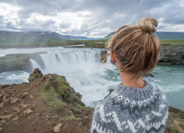 Woman stood in front of one of the waterfalls in iceland