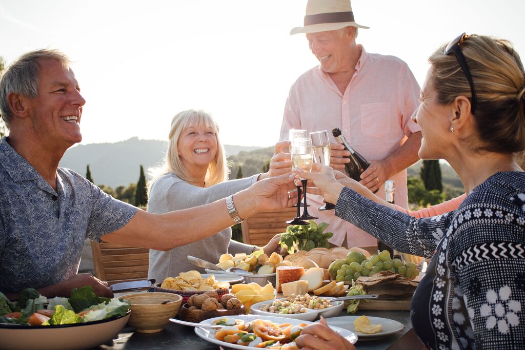 A group of people clinking glasses over their dinner