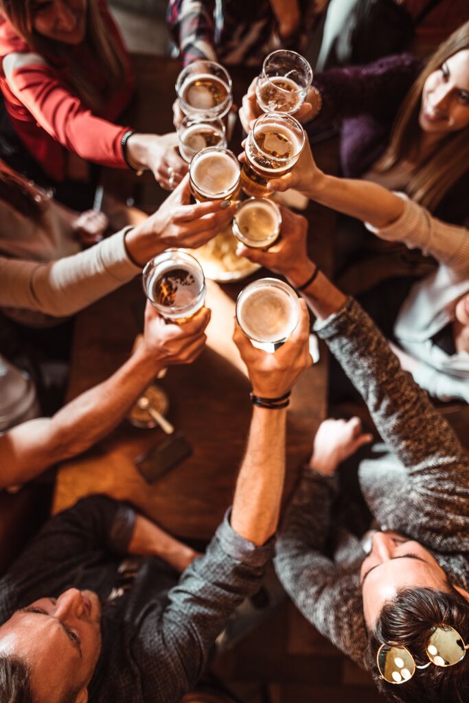 A large group of people clinking beer glasses 