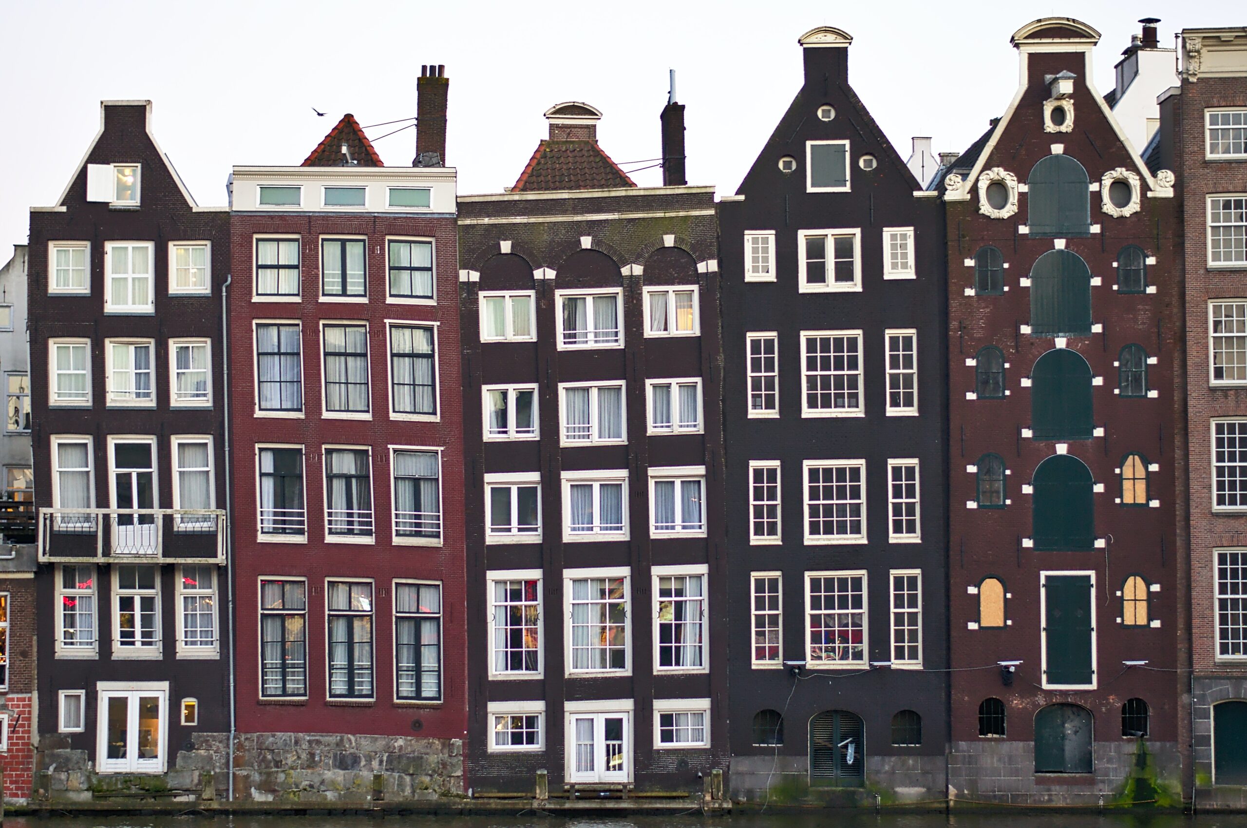 Image of tilting houses, five in a row, thin and tall