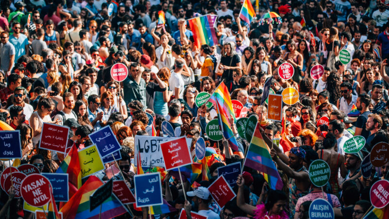 Image of annual Gay pride in Istanbul showing off a multitude of colorful flags and placards calling for equal rights and justice for LGBTQI+ related crime.