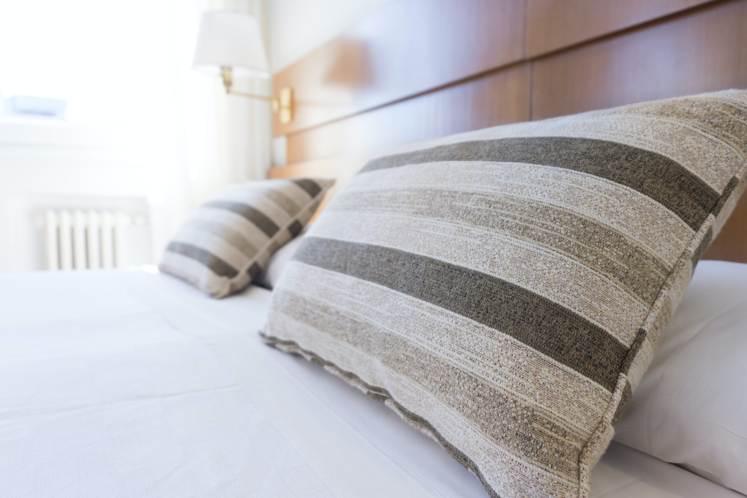 Close up generic image of hotel bed, with two pillows and white linen