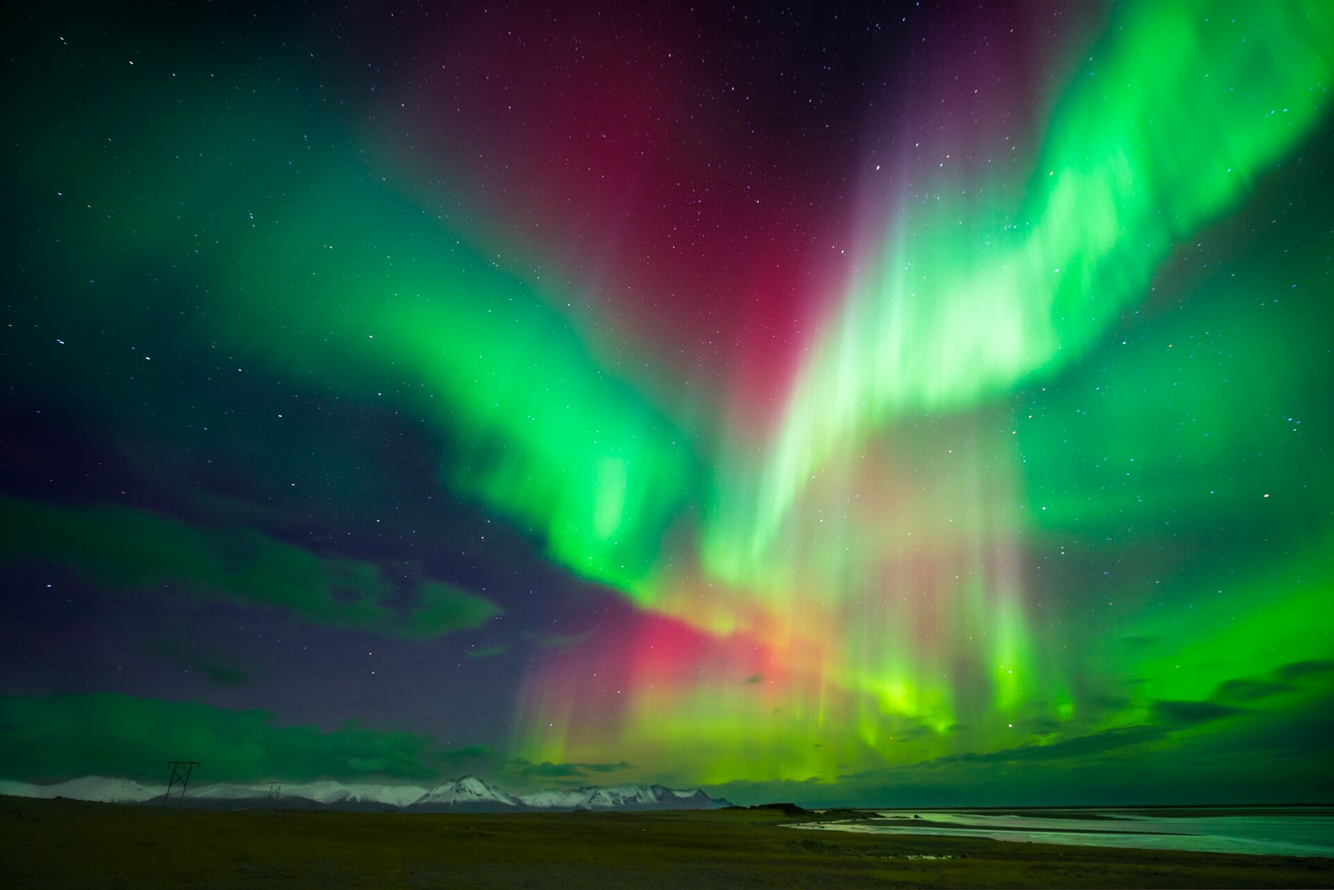 bright red and green northern lights criss cross the night sky in Scandinavia