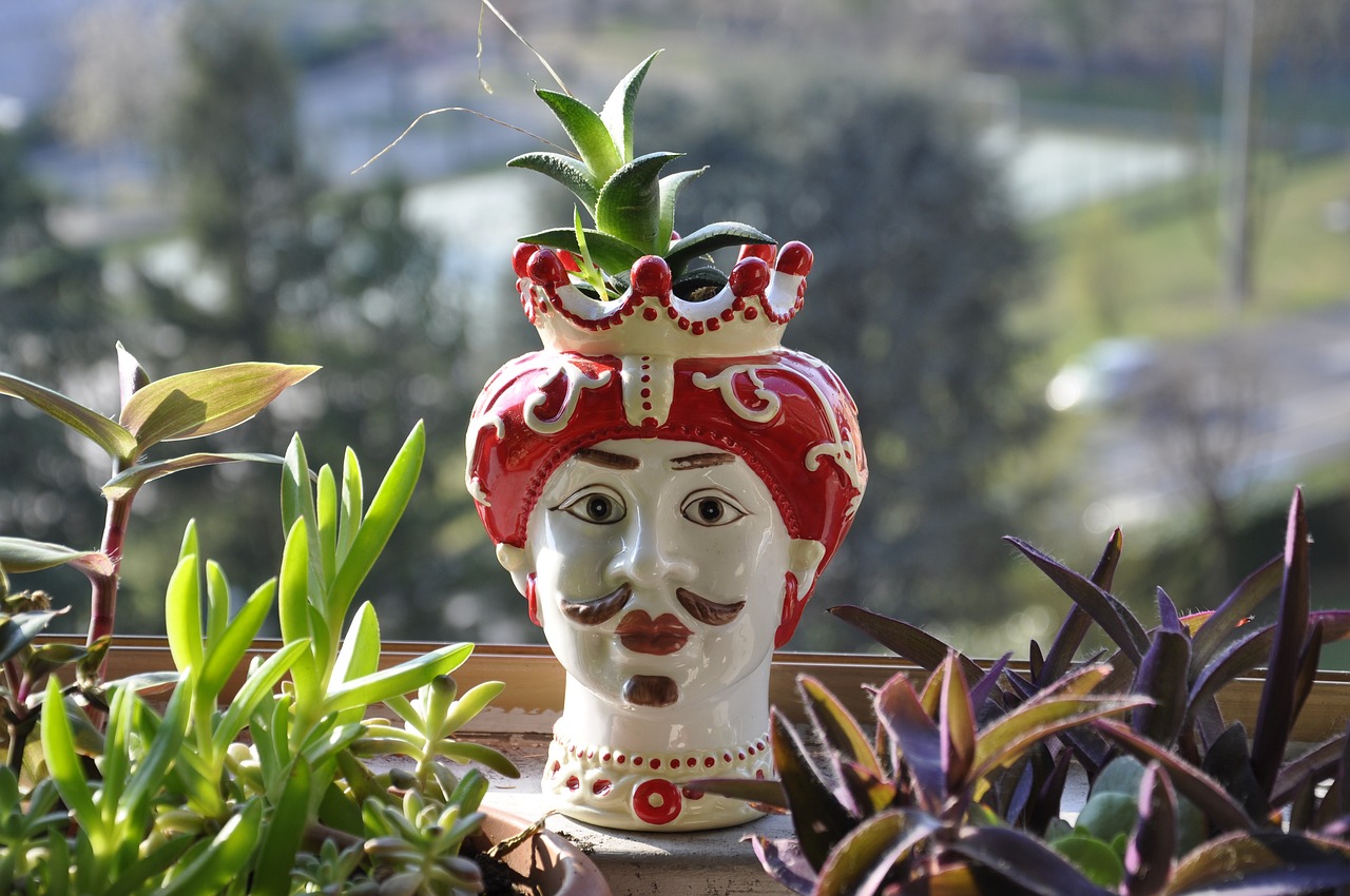 Brightly painted ceramic figure of a head, with a red headdress and a moustache, known as a sicilian moor head figurine.
