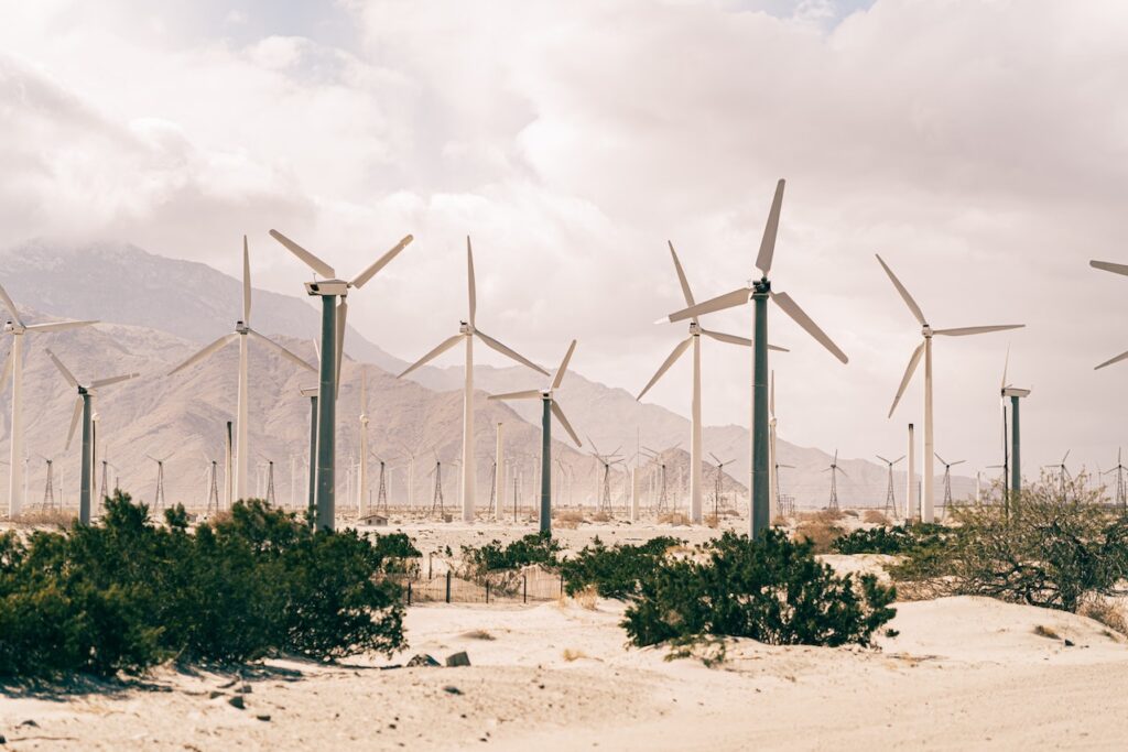 wind turbines in desert landscape with mountains in background