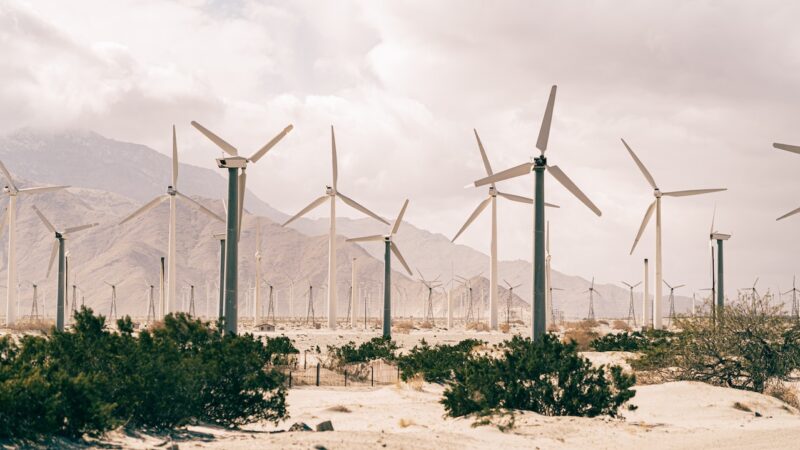 wind turbines in desert landscape with mountains in background