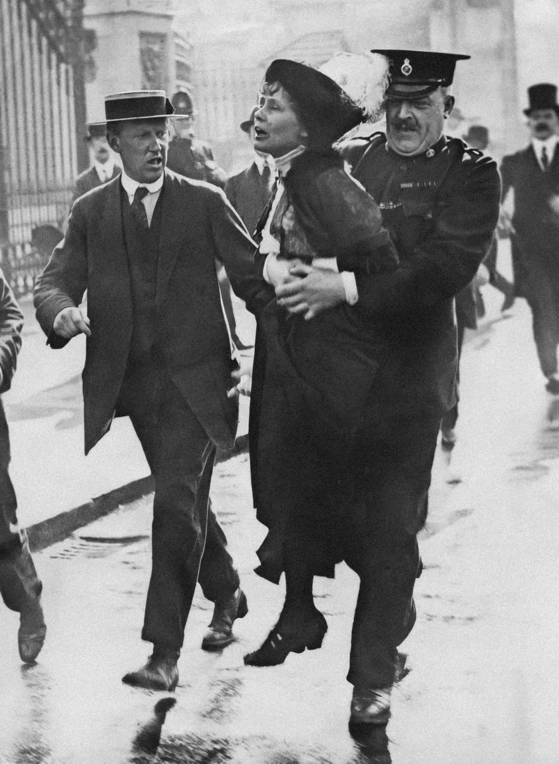 Historical black and white image of a Suffragette being arrested by a police officer