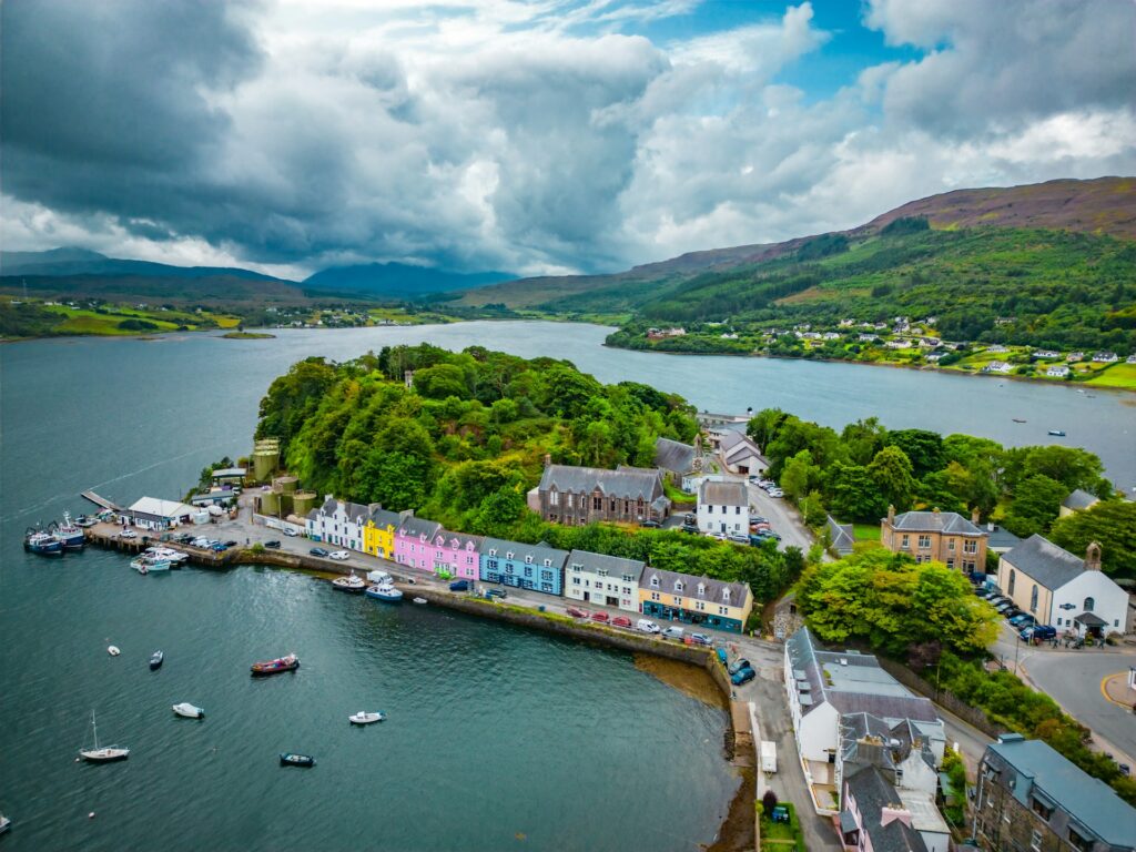 Photo of colorful houses in a small harbour on the Isle of Skye, landscape and water stretching into the distance