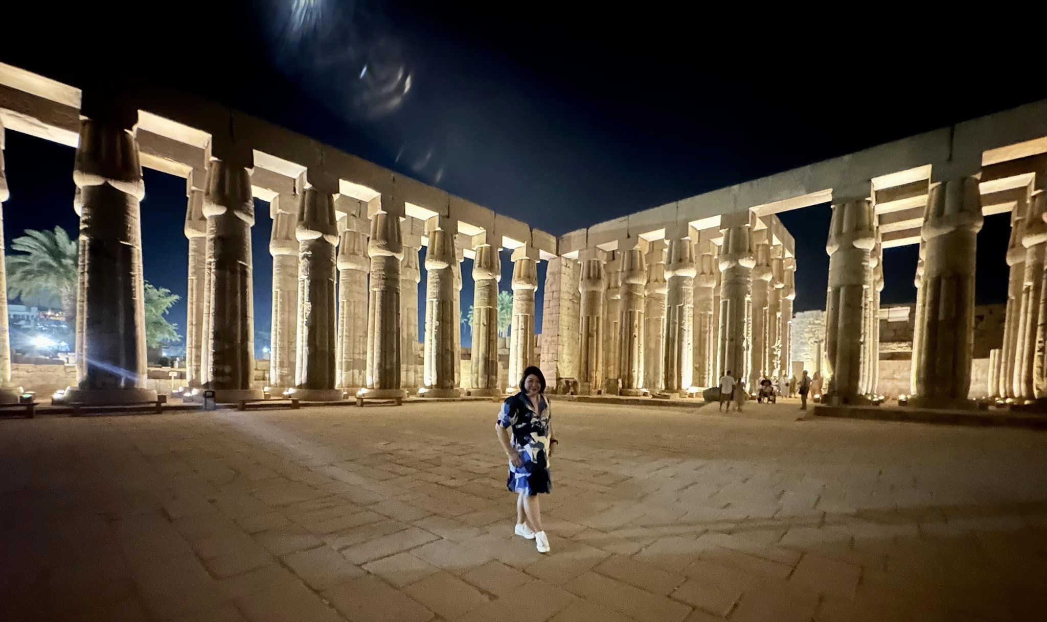 Mae stands alone in front of the pillars of the Temple of Luxor