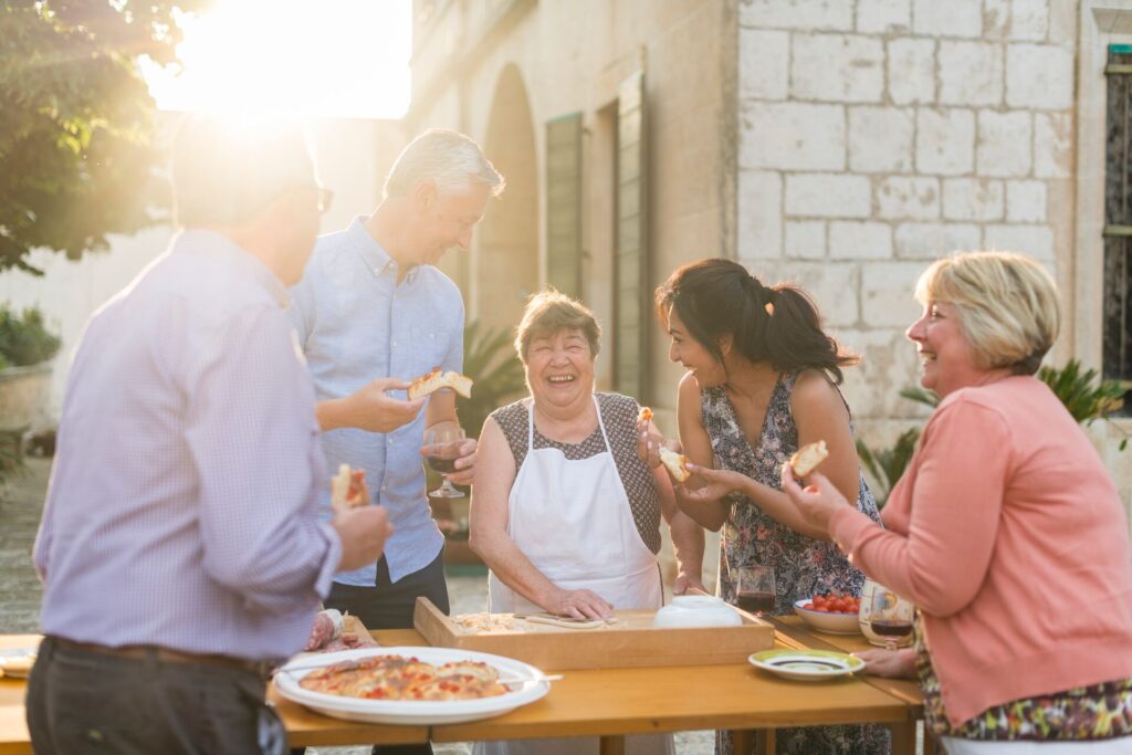 A group of people indulging in pizza at an outdoor table, experiencing the delights of food tourism.