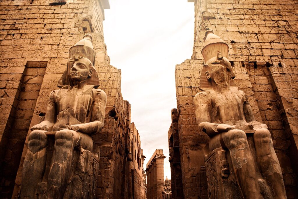 Egyptian statues line a thin alleyway