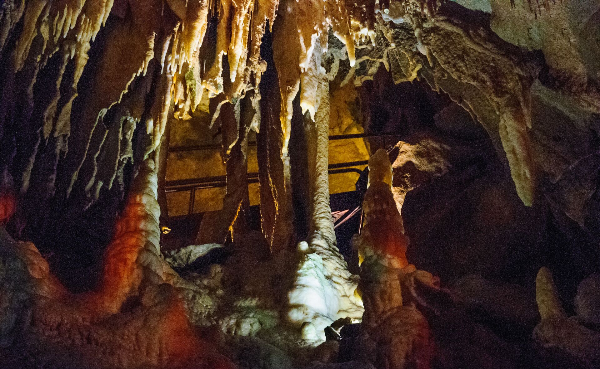The brown and gold interior of Mammoth caves is shown with interesting shapes in the rock.