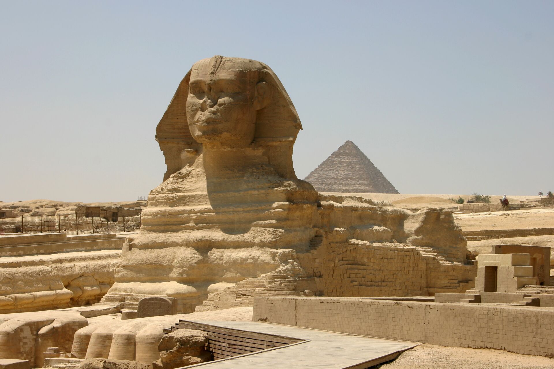 Gigantic golden stone sphinx with a pyramid in the background in Egypt