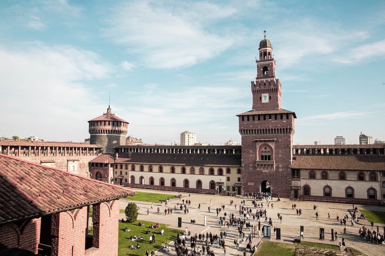 The corner and gate of the Castello in Milan on a beautiful blue day.