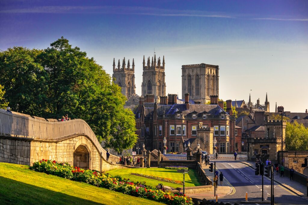 Photo of York, taken in golden sunlight, with York Minster visible over the rooftops of houses