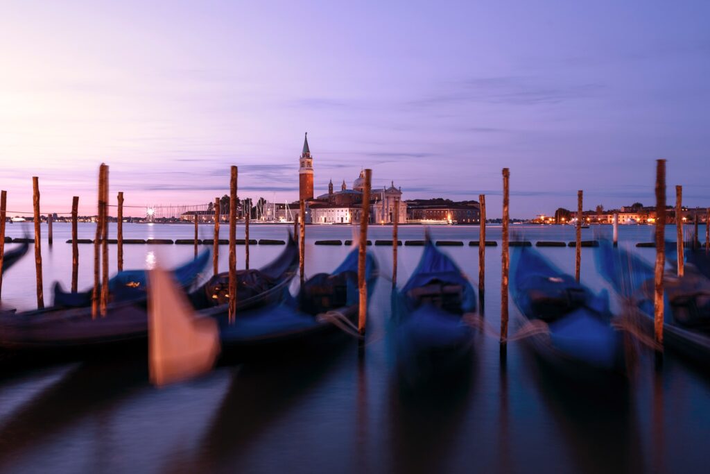 Gondolas moored on stakes on Venice's Grand Canal, shot at sunset