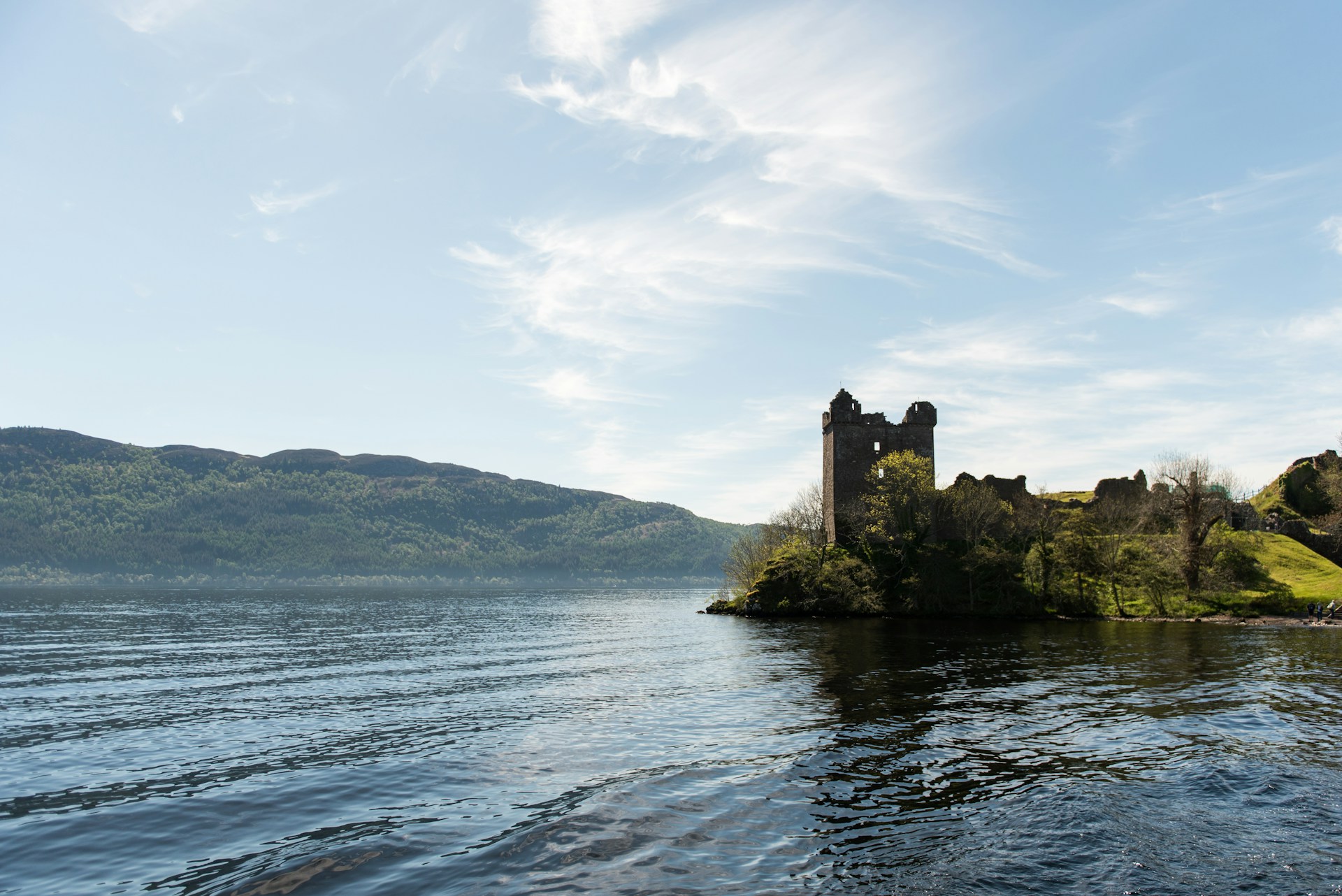 Loch Ness photographed from near the water, looking across the surface towards hills on the far side