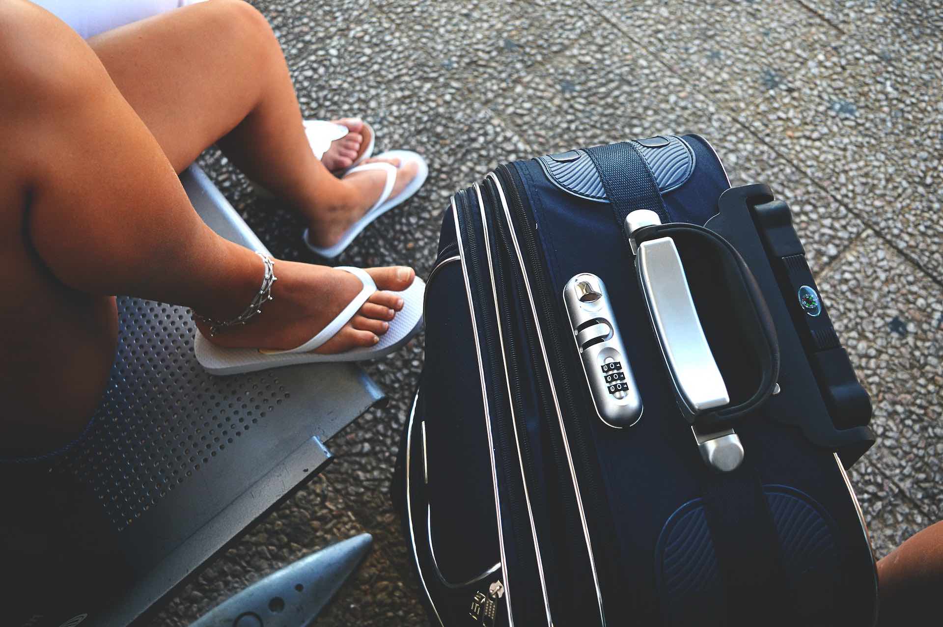 Image of female legs next to a suitcase