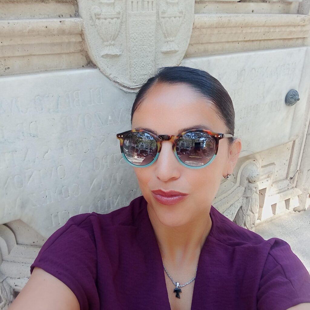 A picture of Vania, one of our global travel experts, posing for a selfie with sunglasses on