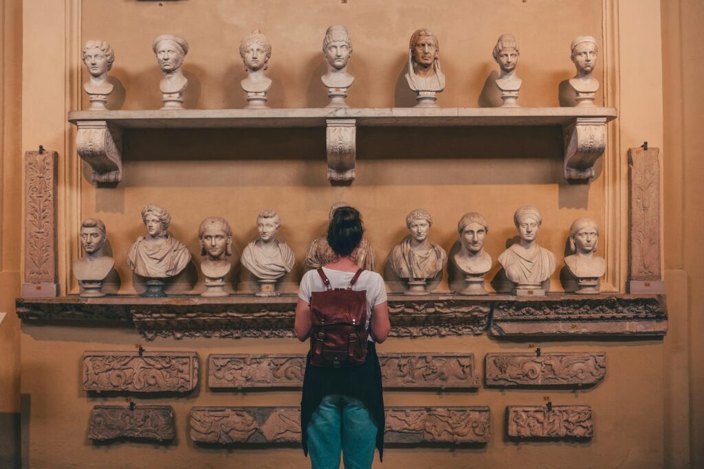 woman looking at Roman stone busts in a museum