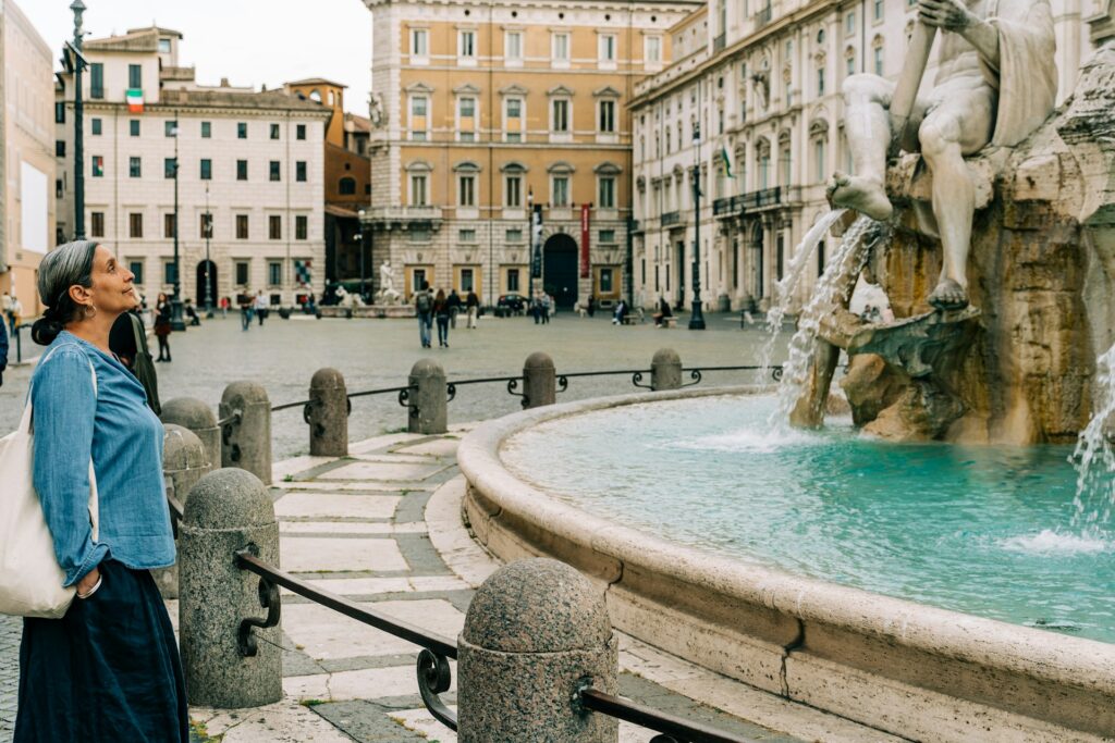 Woman standing looking at a fountain in Rome