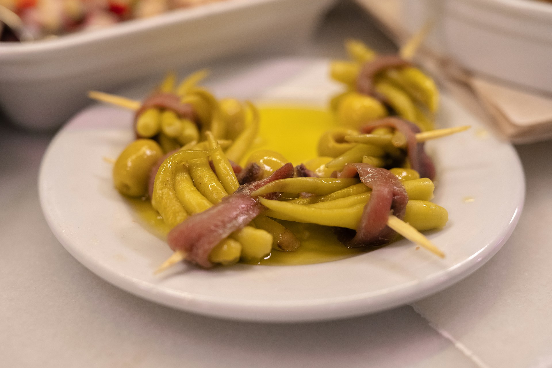 Basque pintxo dish of green finger chillies wrapped in anchovies