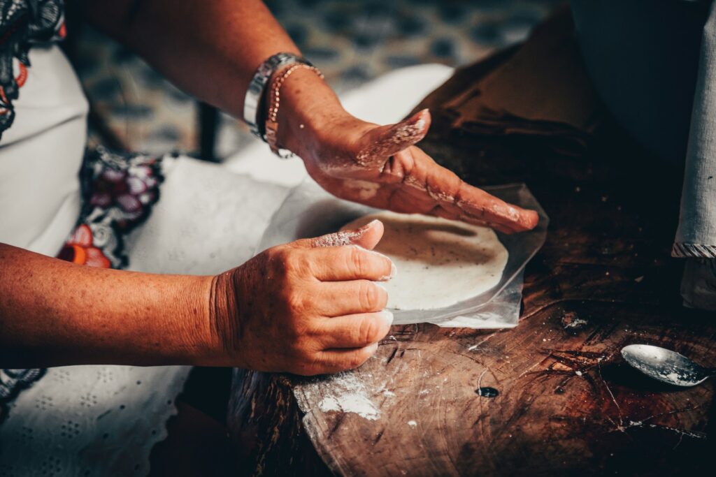 Close up of a woman's hands making small tortillas