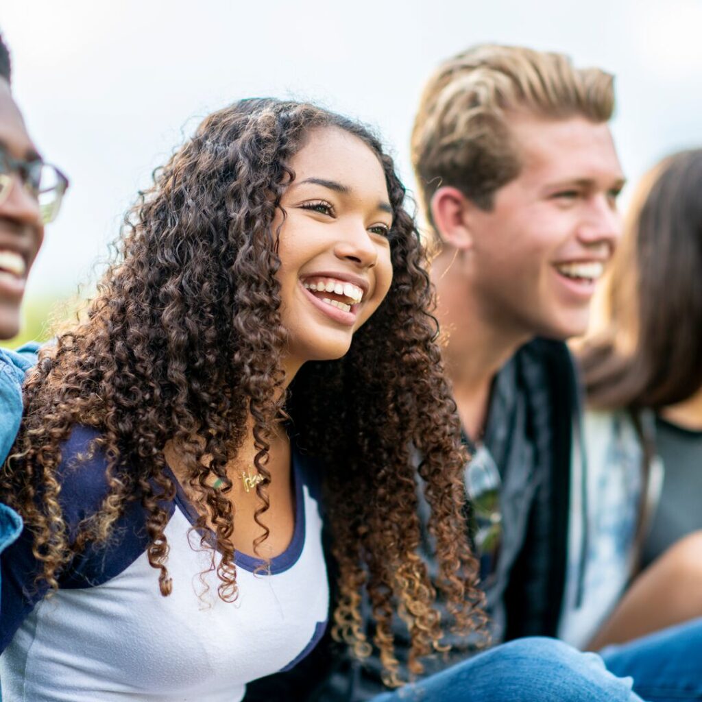 Teenagers smiling while looking at something off camera