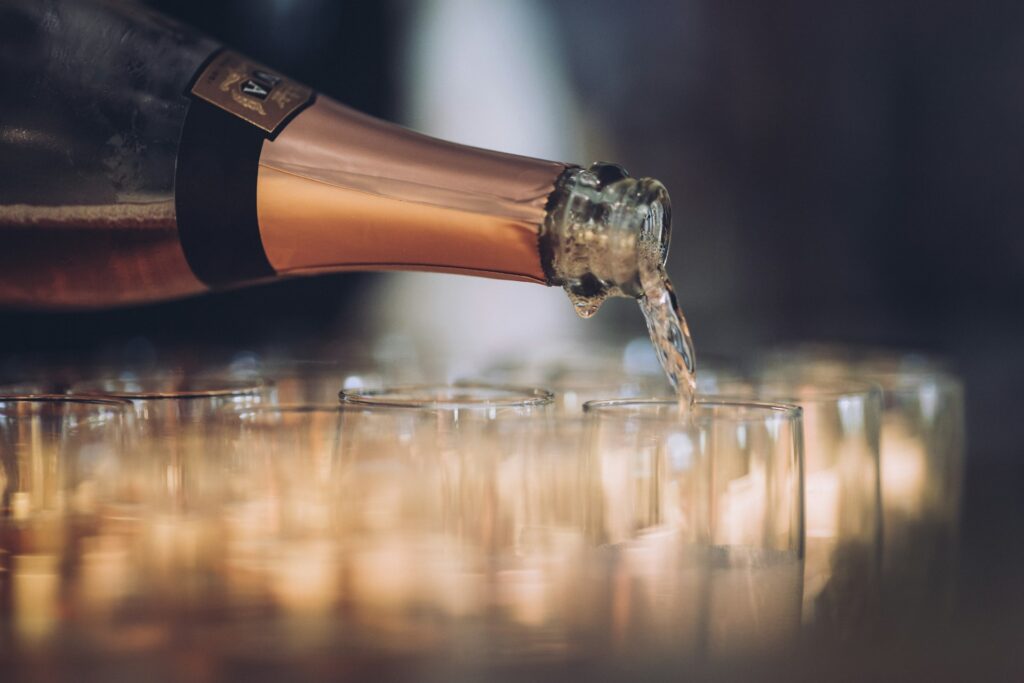Champagne bottle filling up glasses with blurred background