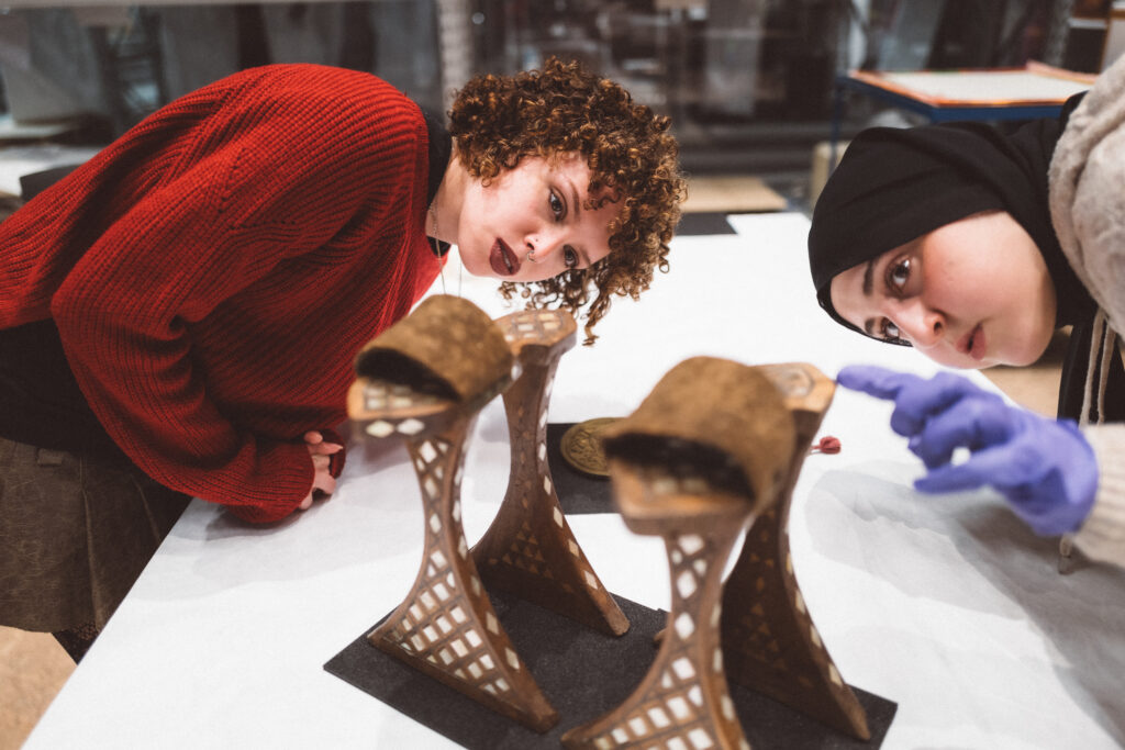 Two women looking closely at a museum object